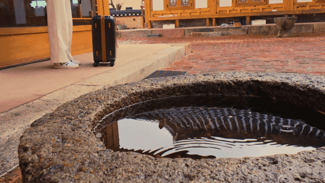 여행 가방이 놓인 비 오는 한옥