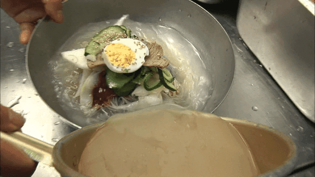 Cold noodles being prepared with broth