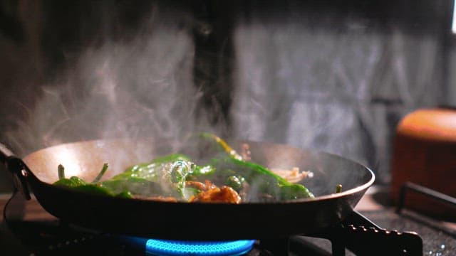 Stir-frying vegetables in a smoky pan