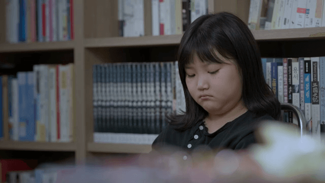 생각에 빠진 도서관 속 아이