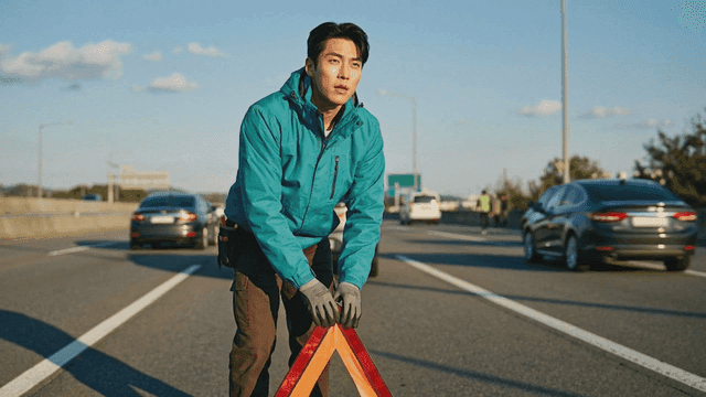 Man setting up a warning triangle on the highway