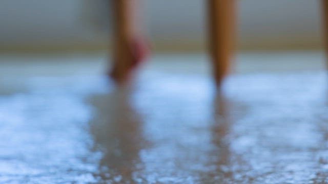 빗물이 고인 바닥을 딛고 의자에 앉아 있는 사람