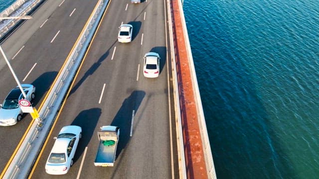 Cars on a Bridge over a City Waterway in the Midday