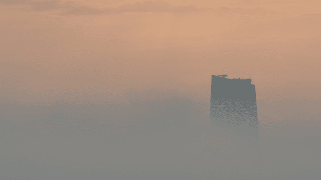A tall building in the morning mist