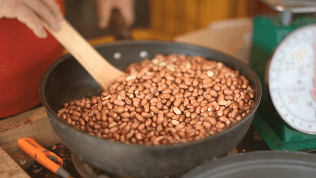 주걱으로 팬에서 땅콩 볶기