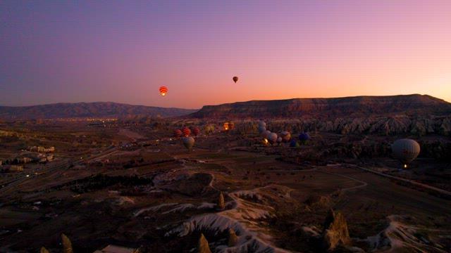 Hot Air Balloons Over Picturesque Landscapes at Dusk