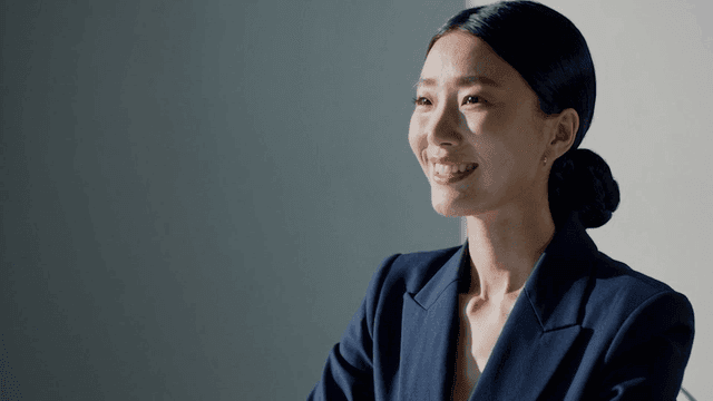 실내에서 미소 짓는 파란 정장 여성