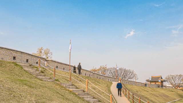 People walking along a historic fortress wall