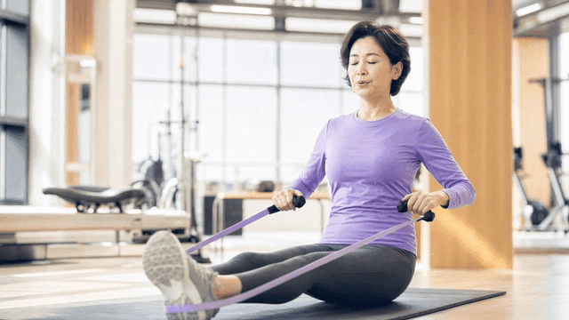 Middle-aged woman exercising with resistance bands