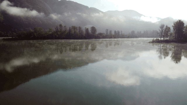 Tranquil lake surrounded by misty mountains