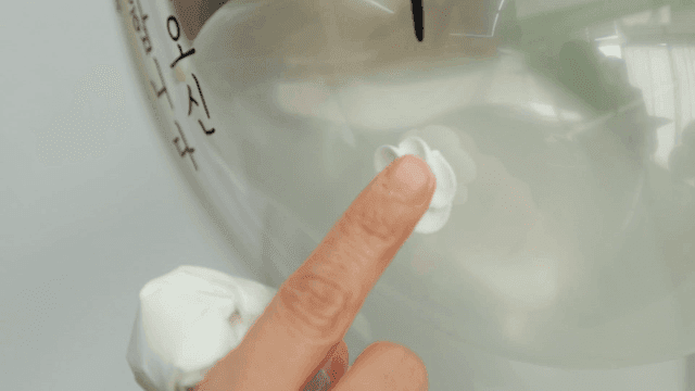 Hand attaching flower decorations to balloon