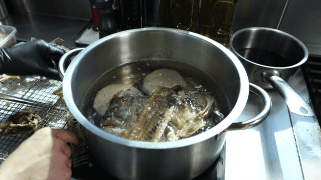 Dried fish heads boiling in pot with radish
