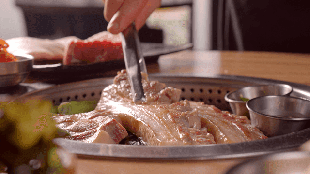 Grilling pork belly on a tabletop grill