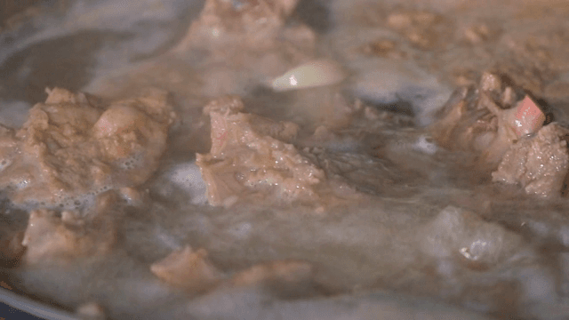 냄비에서 끓고 있는 고기와 마늘