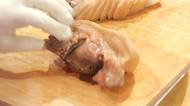 Slicing boiled pork on a cutting board