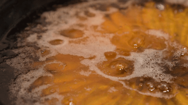 팬에서 뜨거운 기름에 생선 튀기기