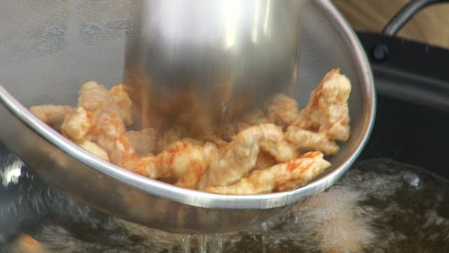 기름에서 노릇노릇하고 바삭한 돼지고기 탕수육 건져내기