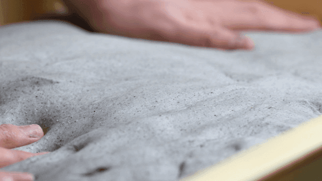 Hands kneading dough in a tray