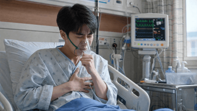 Young male patient in hospital room wearing oxygen mask