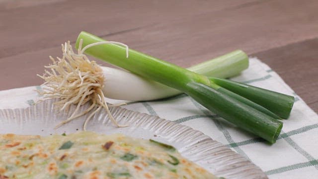 파와 함께 테이블에 놓인 노릇노릇한 파전