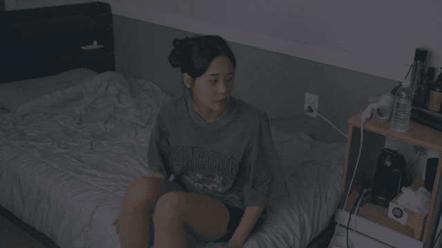 어두운 방 침대에 좌절하며 앉아 있다 일어서는 여성