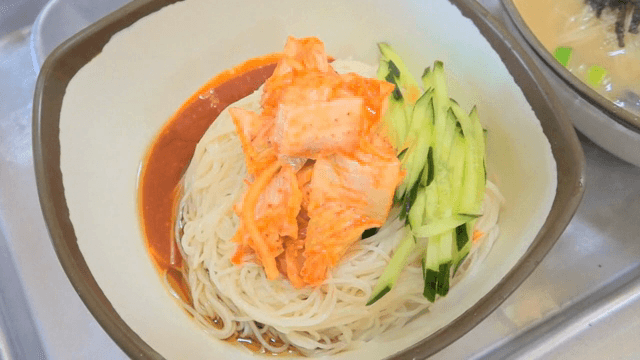오이와 김치가 올려진 비빔국수