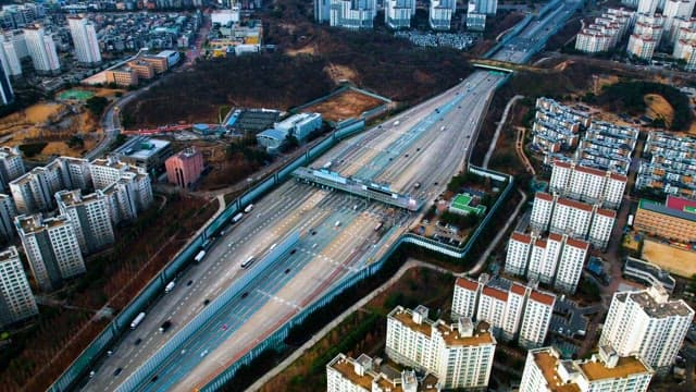 번화한 도시의 고속도로 위를 달리는 자동차들