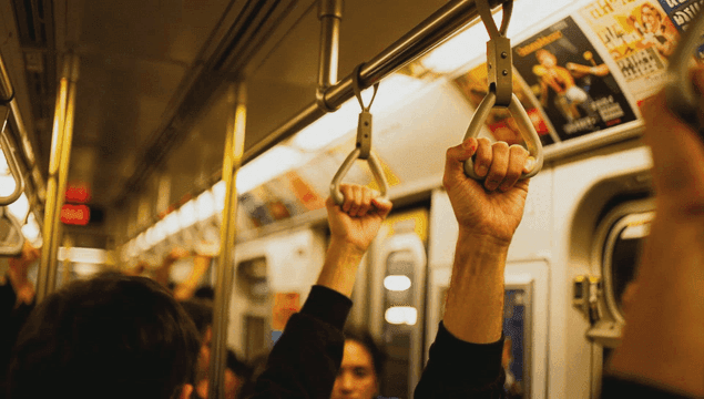 People holding subway handles