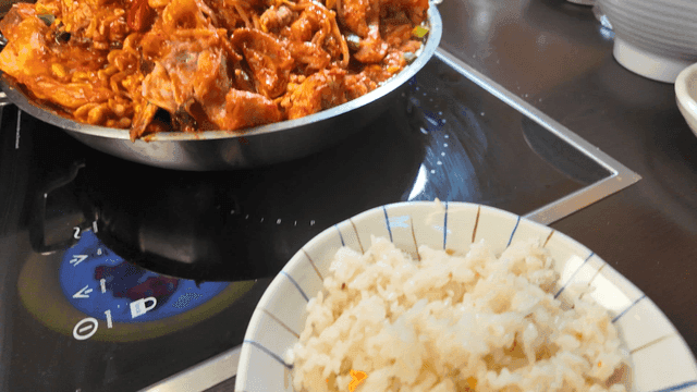 Chopsticks holding rice and spicy braised anglerfish.