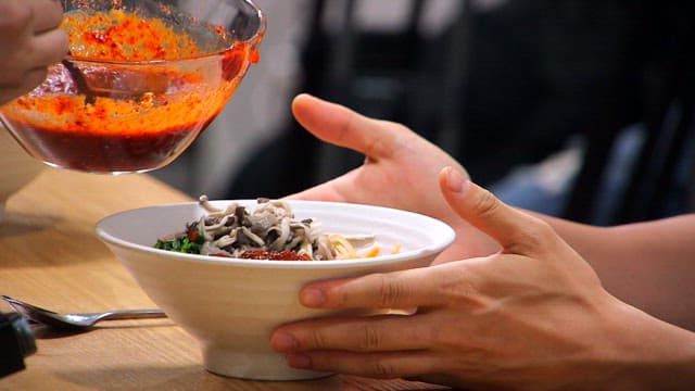 느타리버섯이 올라간 비빔밥 그릇에 고추장을 넣는 모습