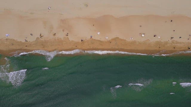 여름을 즐기는 피서객들이 있는 파도 치는 해변