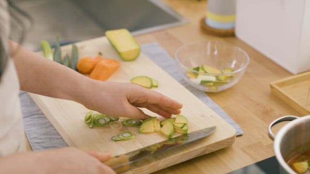 된장찌개에 썰어둔 애호박을 넣는 손