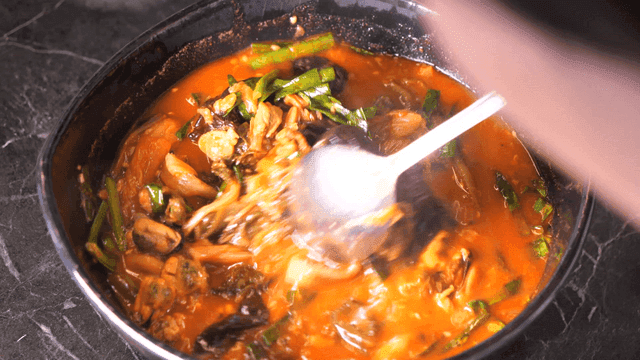 Man eating spicy Korean sundubu jjambbong