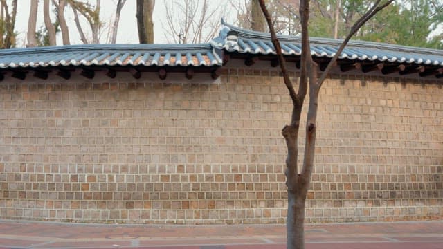 Traditional Korean wall with people passing by