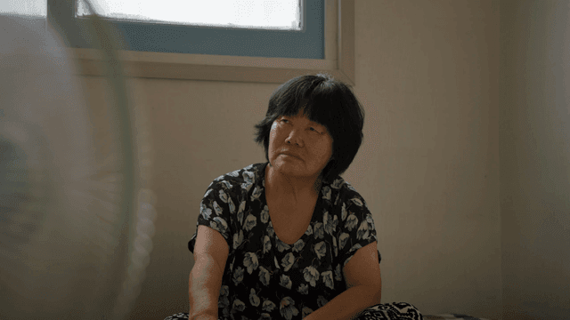 An elderly woman sitting indoors