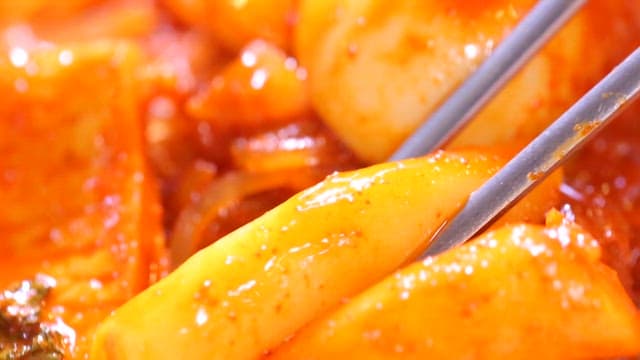 Spicy tteokbokki held with chopsticks