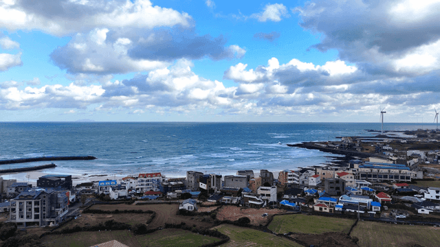 Coastal village with ocean views and wind turbines