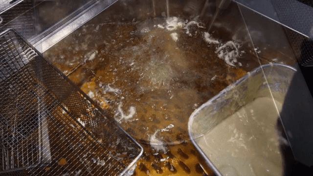 반죽을 입힌 바나나를 뜨거운 기름에 튀기는 장면