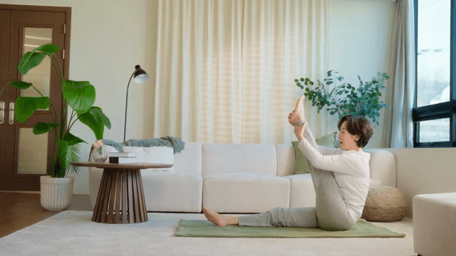 Woman practicing yoga in a cozy living room
