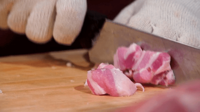 Cutting pork belly on a wooden board