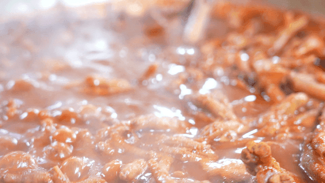 Spicy chicken feet simmering in sauce