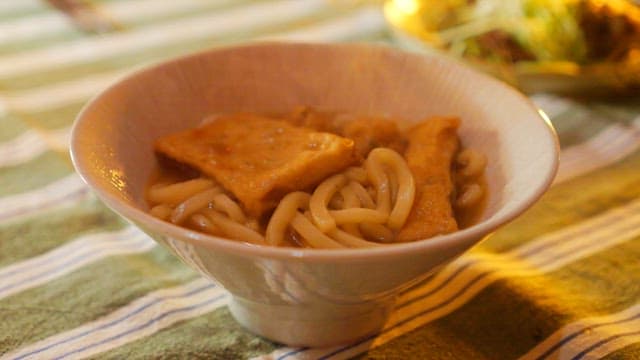 Delicious udon noodles with fish cakes served on a cozy table