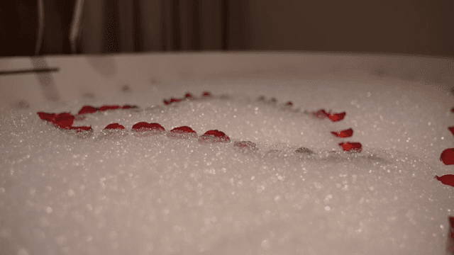 장미 꽃잎으로 하트 모양을 만든 욕조