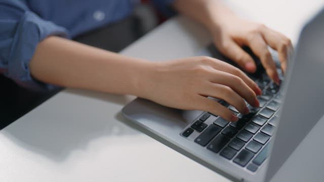 노트북 키보드를 타이핑하는 손