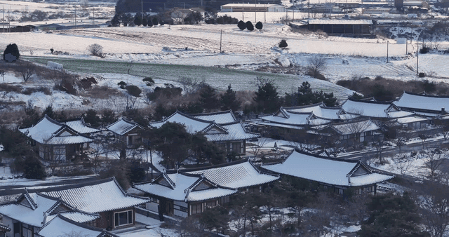 Traditional Hanok village with snow-covered tile roofs