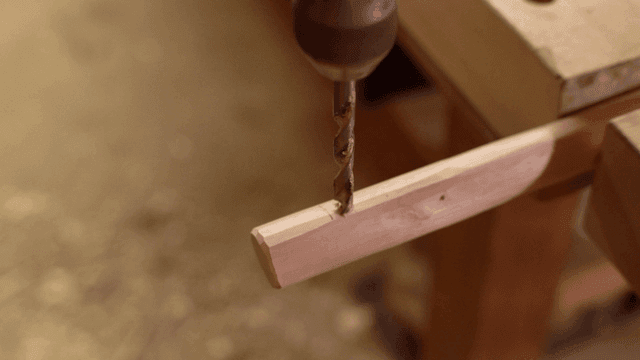 나무 조각에 구멍을 뚫는 장면