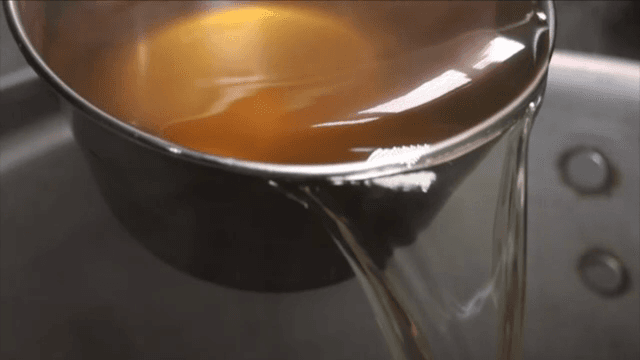 Pouring broth from a ladle into a pot