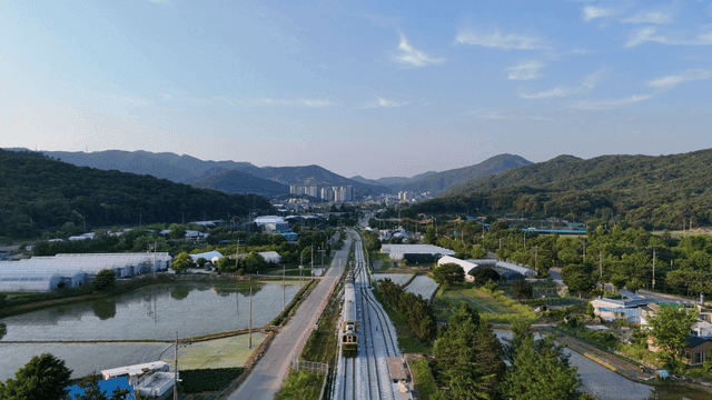 Rural scenery with greenhouses and train tracks