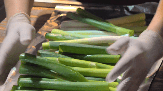 Chef arranging green onions on foil