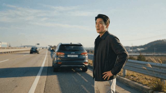 Man standing by road and passing cars